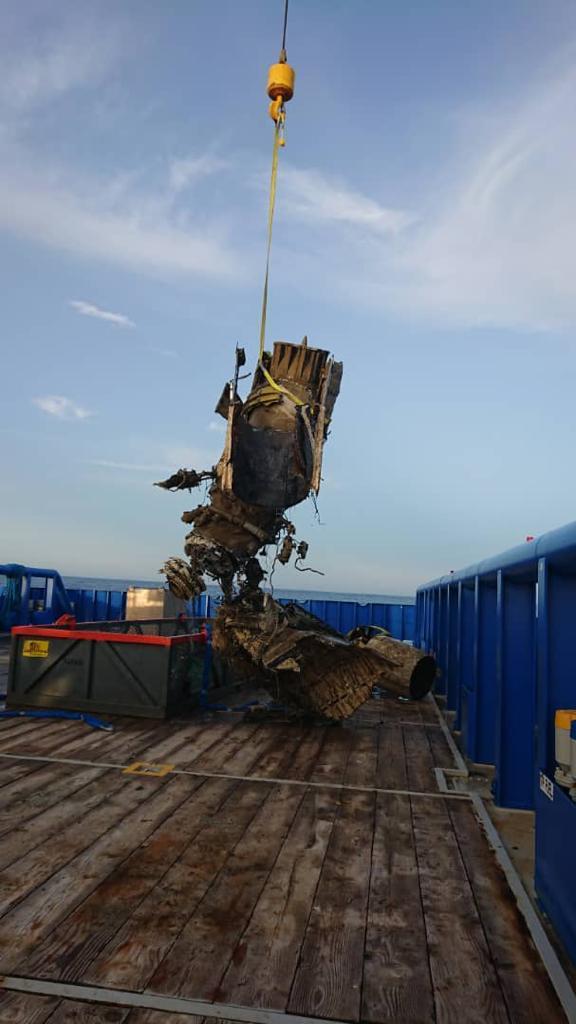 Aircraft wreckage being lifted onto recovery vessel deck