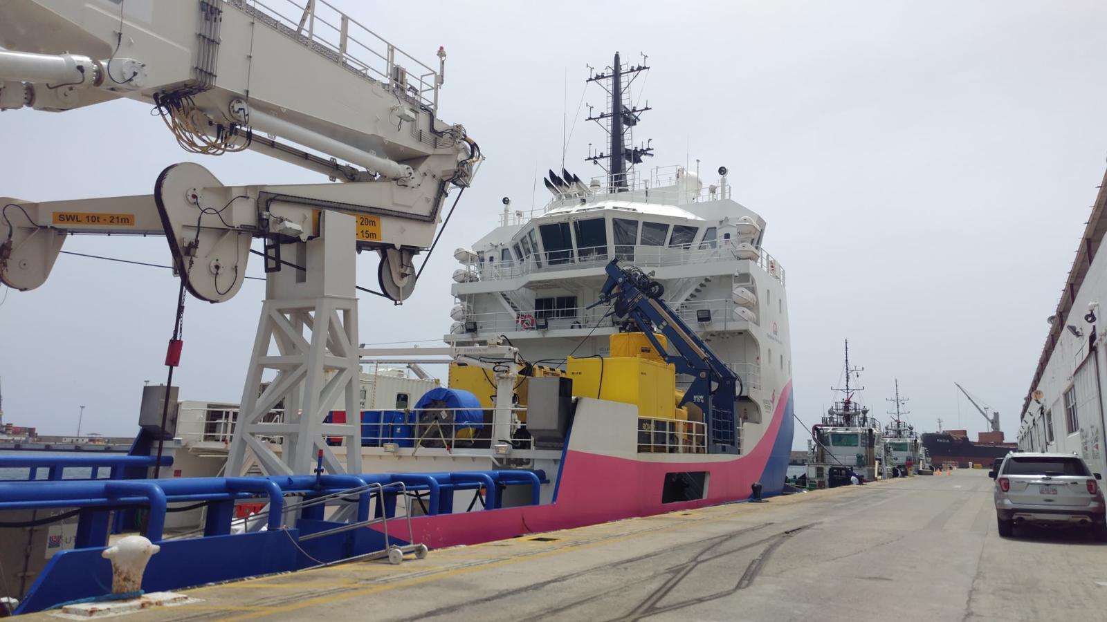 Offshore support vessel with crane alongside at port